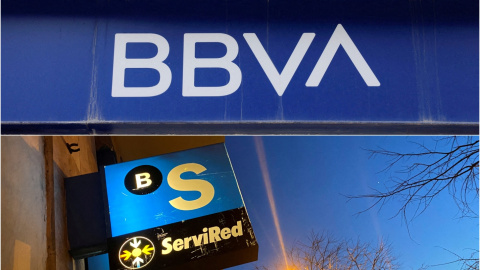 Los logos del BBVA y del Banco Sabadell en sendas oficinas bancarias.