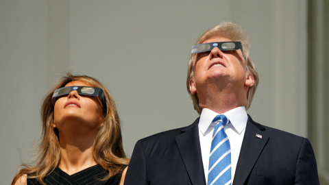 El presidente de EEUU, Donald Trump, y su esposa Melania observan el eclipse de Sol en la Casa Blanca, en Washington (EEUU). REUTERS/Kevin Lamarque