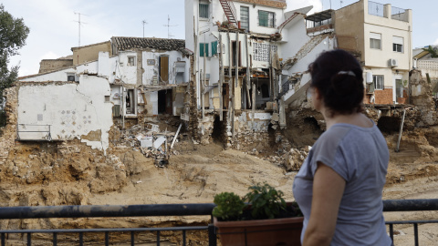 Una mujer observa varias casa dañadas por la Dana en Chiva, València,