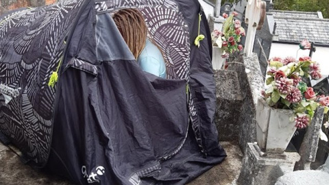 Mujer acampada sobre un nicho en el cementerio de San Lázaro en Lugo, Galicia, el pasado 2 de octubre.