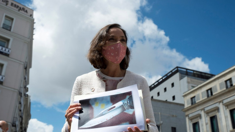 La ministra de Industria y Comercio, Reyes Maroto, muestra una fotografía de la navaja ensangrentada que ha recibido dentro de un sobre esta mañana, a su salida del Congreso de los Diputados este lunes.