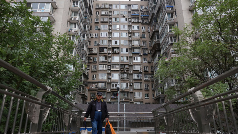 Un hombre cruzo un puente cerca de un edificio residencial en Pekín. REUTERS/Florence Lo