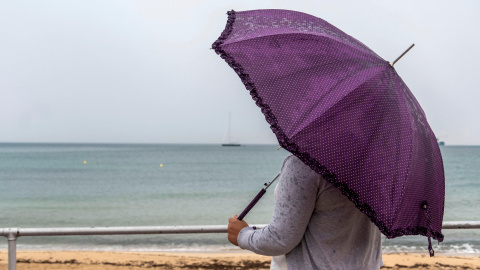 Una mujer se protege de la lluvia este viernes en Palma de Mallorca. EFE/Cati Cladera