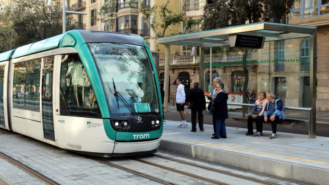 Usuaris esperen el tramvia a l'estació de Verdaguer malgrat l'ajornament de la posada en marxa del servei.