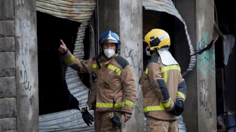 Los bomberos supervisan las tareas de desescombro y demolición de la nave ocupada de Badalona. — Alejandro García / EFE