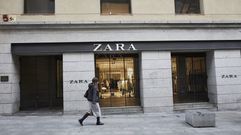 Una mujer pasa al lado del primer local de Zara que abrió en Madrid, junto a la Puerta del Sol, y que ha echado el cierre en noviembre.