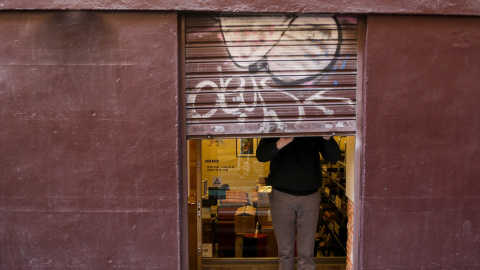 Un autónomo echa el cierre de su negocio, al término de la jornada laboral. E.P./Ricardo Rubio