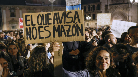 Una manifestante con una pancarta en la protesta por la gestión de la DANA, en València.