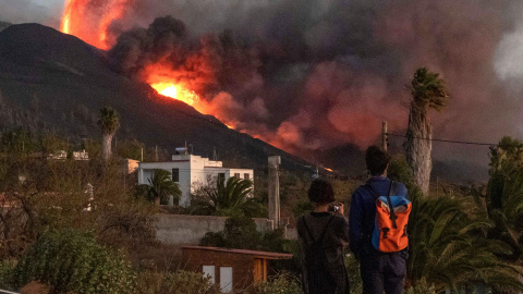 Una pareja observa cómo la lava emerge de la erupción volcánica de Cumbre Vieja, en la isla canaria de La Palma este 29 de septiembre de 2021.