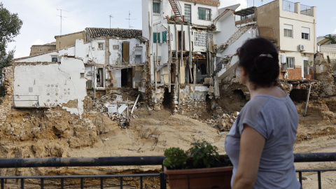 Una mujer frente a varias casas dañadas en Chiva, València, tras la DANA.