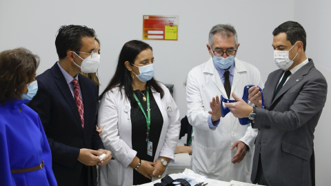 El presidente de la Junta, Juanma Moreno (d), junto a varios sanitarios en la presentación de 'Gammaknife' en el Hospital Virgen de las Nieves de Granada.