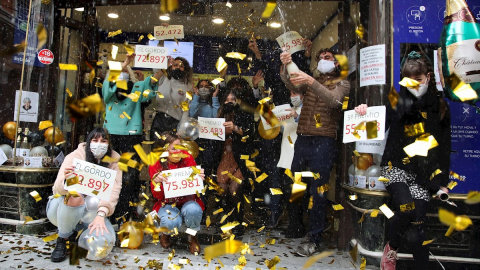 Loteros de la administración de "Doña Manolita" de Madrid festejan haber vendido décimos del premio gordo que ha recaído en el número 72.897.