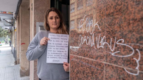 Mirian Armero, cajera de un supermercado de Cartagena, muestra en el portal del edificio donde vive, la carta que un vecino metida por debajo de su puerta y que encontró su hijo de 10 años, en la que le recomiendan que se busque otra vivienda mientras d