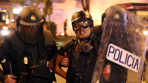 El moment en què la Policia Nacional s'endú detingut i emmanillat per l'esquena el fotoperiodista d'El País Albert Garcia a la plaça Urquinaona de Barcelona el 18 d'octubre del 2019.