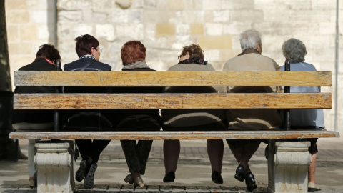 Varios ancianos sentandos en un banco en el pueblo burgalés de Bribiesca. AFP