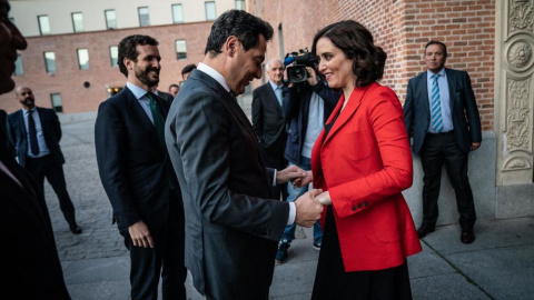 El presidente andaluz, Juanma Moreno Bonilla, saluda a la presidenta madrileña Isabel Díaz Ayuso, en presencia del líder nacional, Pablo Casado, en una imagen de archivo.