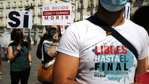 Un grupo de personas se reúne sosteniendo pancartas y carteles durante la concentración de la asociación Derecho a Morir Dignamente (DMD) en la Puerta del Sol, a 25 de junio de 2021, en Madrid, (España).