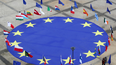 Una enorme bandera de la Unión Europea, rodeada junto a otras de los diferentes países comunitarios, aparece desplegada en la Plaza Schuman, frente a la sede de la Comisión Europea, en Bruselas, con motivo del Día de Europa. REUTERS/Yves Herman