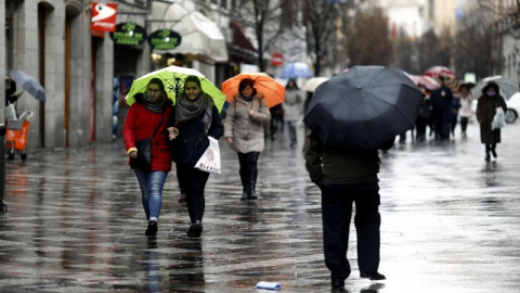 Imagen de archivo de ciudadanos paseando el frío y la lluvia. EUROPA PRESS/Óscar del Pozo