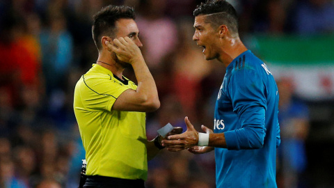 El jugador del Real Madrid Cristiano Ronaldo protesta ante el árbitro Ricardo de Burgos Bengoetxea por su expulsión en el partido de ida de la Supercopa de España en el Nou Camp. REUTERS/Juan Medina