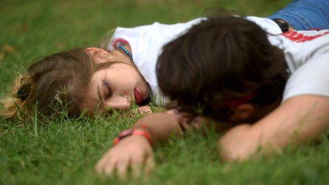 Dos personas durmiendo en el césped. REUTERS/Archivo.