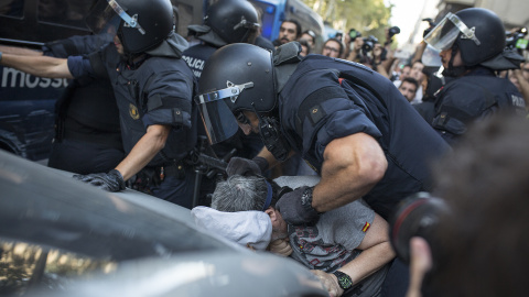 Un policia immobilitza un manifestant xenòfob que ha propinat un cop de puny a un contramanifestant antifeixista. FOTO: Raül Clemente.