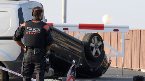 Un agente, junto al coche que usaron los terroristas en su ataque en Cambrils. - AFP