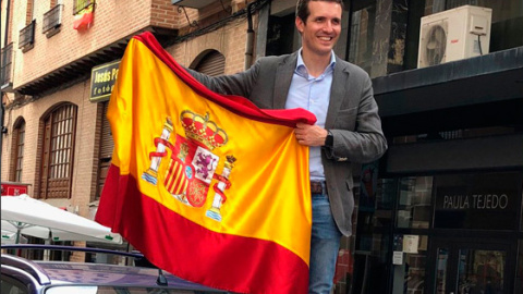 Pablo Casado posando con la bandera de España, subido a un coche. /TWITTER DE PABLO CASADO