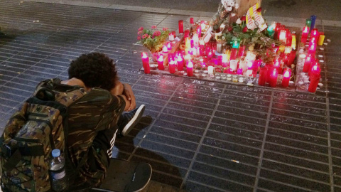 Un jove plora davant un altar improvissat a la Rambla la nit de dissabte. FOTO: Elena Parreño