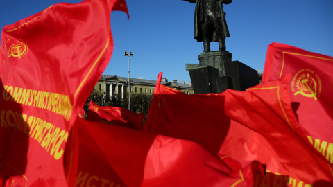 Banderas comunistas frente a la estatua de Vladimir Lenin en San Petesburgo. /REUTERS