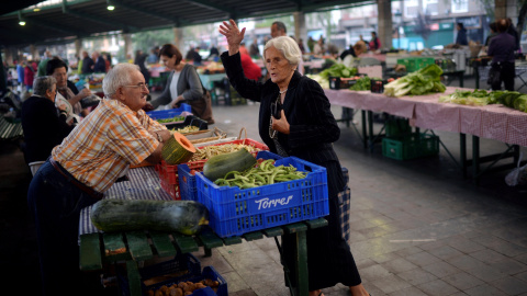 Una mujer hace la compra en un puesto de un mercado de Bilbao. REUTERS