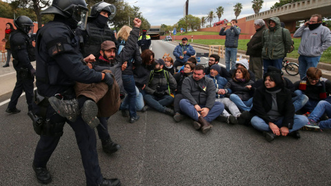 Los Mossos se llevan a una persona en Barcelona durante la huelga en Catalunya. REUTERS/Albert Gea