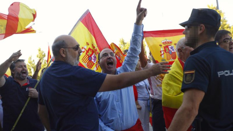 Un grupo de ultras, con banderas de España, increpan a los miembros de Unidos Podemos a las puertas de su asamblea en Zaragoza. /EFE