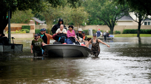 Varios vecinos de Houston usan un bote para salir de sus casas. - REUTERS