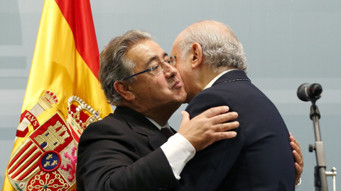 Zoido se abraza a su antecesor en el cargo, Fernández Díaz. | EFE