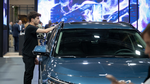 Un joven frente a un vehículo en una imagen de archivo tomada antes del inicio del Automobile Barcelona 2023, a 11 de mayo de 2023