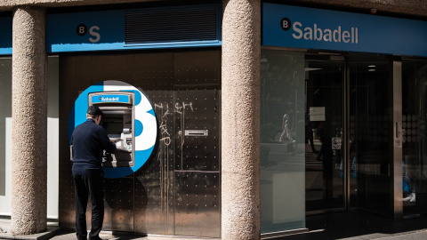 Un hombre opera el cajero automático de una oficina del Banco Sabadell en Madrid. E.P./Diego Radamés