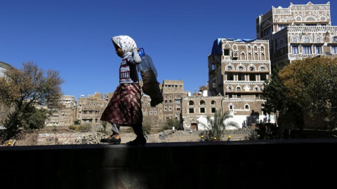 Una niña camina junto a edificios históricos destruidos por los bombardeos de la coalición árabe liderada por Arabia Saudí en Saná, Yemen. Las autoridades del país planean la reconstrucción de dos edificios destruidos el pasado 12 de junio. La Org