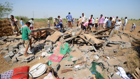 Un grupo de personas permanece de pie junto a una casa destruida por los ataques aéreos de la coalición árabe en Yemen. REUTERS/Abduljabbar Zeyad