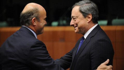 El ministro de Economía, Luis de Guindos, con el presidente del BCE, Mario Draghi, en una reunión del Eurogrupo en Bruselas. AFP