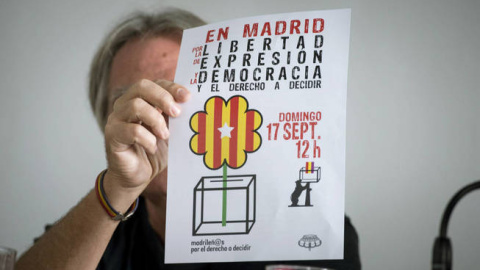 Un activista muestra el cartel del acto de 'Madrileños por el derecho a decidir', en una rueda de prensa este miércoles. EFE