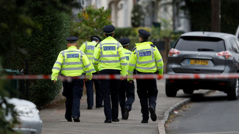 Policías caminan detrás del cordón de seguridad instalado en las casa del segundo sospechosos detenido en relación con el atentado en el metro de Londres. REUTERS/Peter Nicholls