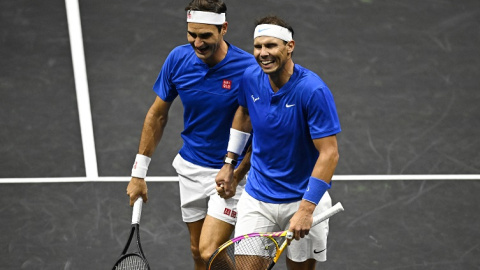 Roger Federer y Rafa Nadal se dan la mano emocionados durante un momento del partido de despedida del tenis del suizo.- Dylan Martinez / Reuters