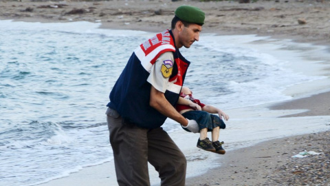 Un agente turco recoge el cadáver de Aylan. - REUTERS