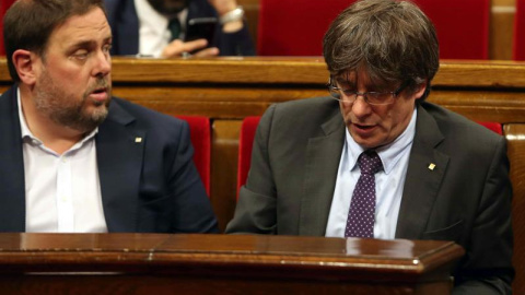 El presidente de la Generalitat, Carles Puigdemont (d) y el vicepresidente del Govern, Oriol Junqueras (i), abandonan hoy el hemiciclo del Parlament de Cataluña a los pocos minutos de iniciarse la sesión a causa de la petición del PPC de suspenderse pa