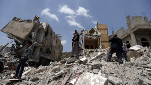 Varios yemeníes sobre las ruinas de un edificio de la capital del país, Sanaa, derruido por los bombardeos. APF/Mohammed Huwais