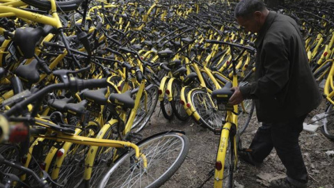 Un mecánico repara una bicicleta de alquiler de la compañía OFO en un depósito que alberga miles de estos vehículos en Pekín (China). EFE/Archivo