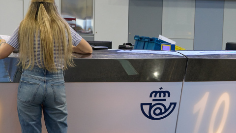 Una chica en el mostrador de la oficina de Correos de Cibeles, a 1 de junio de 2023, en Madrid.