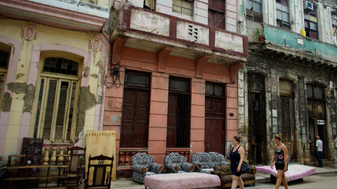 Turistas pasan al lado de muebles puestos a secar en la calle tras las inundaciones provocadas por el huracán Irma en La Habana /REUTERS (Alexandre Meneghini)