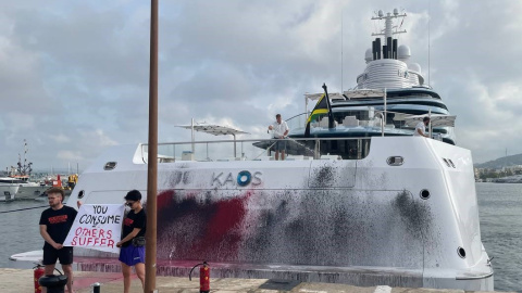 16/07/2023 - Dos activistas despliegan una pancarta frente al yate rociado de pintura, en Ibiza, a 16 de julio de 2023.